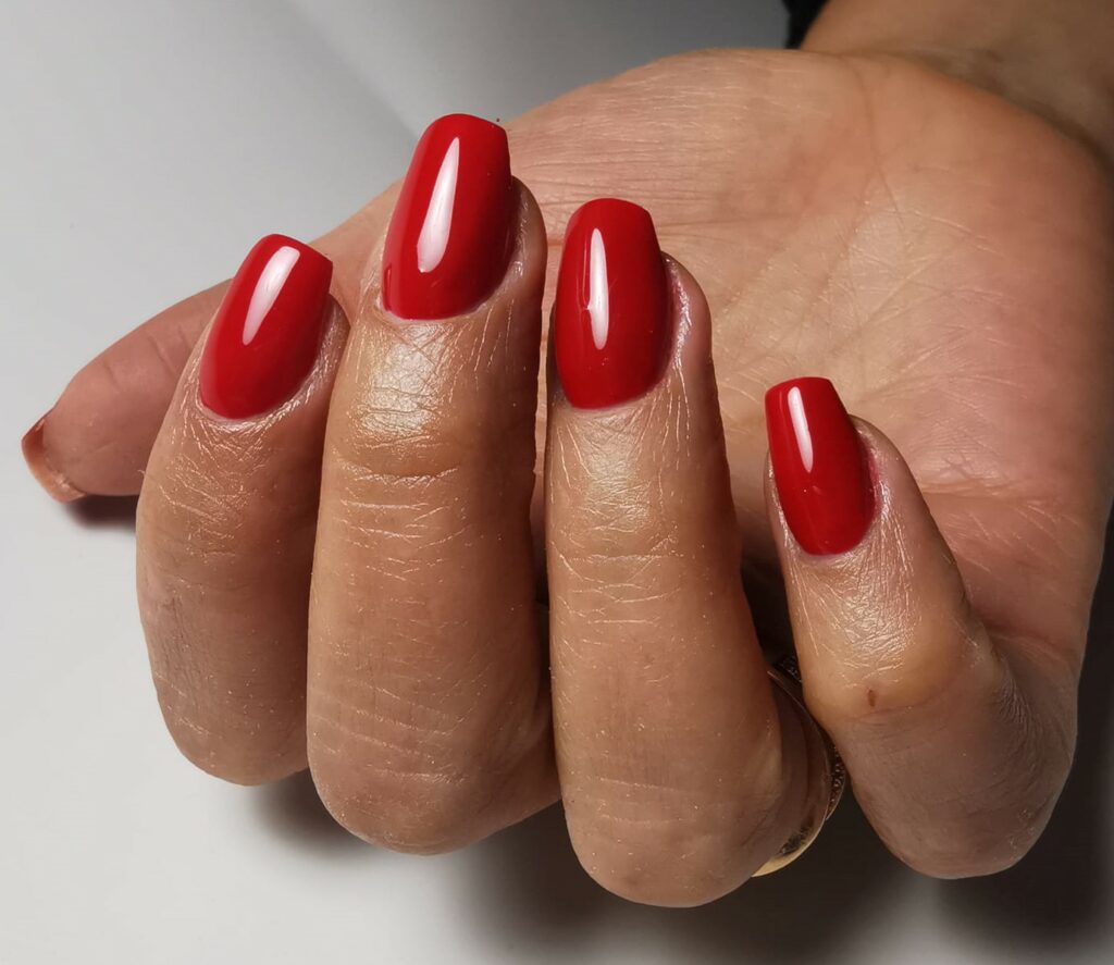 photo d'une main avec belle pose de vernis rouge par la prothésiste ongulaire