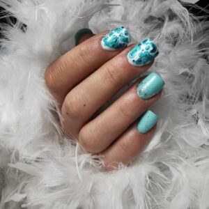 pose-chablon-final photo d'une main avec prestation de pose de prothèses d'ongles couleur bleu turquoise. Fond blanc avec un boa